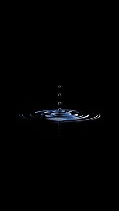 a water drop falling into the dark water