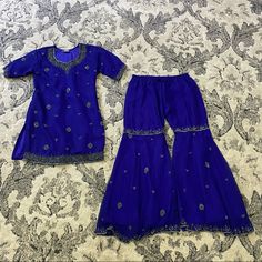 Handmade Girl's Sharara Set In Deep Blue With Embroidered Embellishments. Size: Small Teen Girl Or Extra Small, Short Woman Includes: Top (Extra Long Below Hips) Pants (Chiffon Style With Liner) Condition: Handmade, New. May Show Light Wear Or Discoloration From Storage. Gorgeous One Of A Kind Set. Fitted Blue Sets With Handwork, Festive Blue Fitted Sets, Blue Sharara With Dori Work For Party, Royal Embroidered Sets For Festive Occasions, Fitted Blue Set With Dori Work, Traditional Blue Sharara For Party, Festive Blue Embroidered Sets, Fitted Royal Blue Set For Festive Occasions, Blue Embellished Party Set