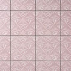 a pink tile wall with an intricate design on the top and bottom half, in different shades