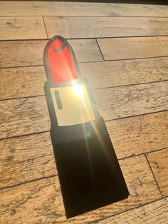 a red and black object sitting on top of a wooden floor