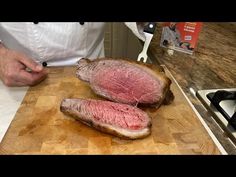 a person cutting up some meat on top of a wooden cutting board