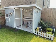 a small white chicken coop in the back yard