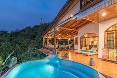 an outdoor swimming pool in front of a house