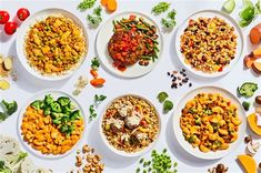 a table topped with plates filled with different types of food and vegtables