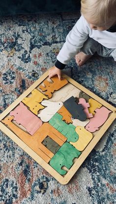 a baby playing with a puzzle on the floor