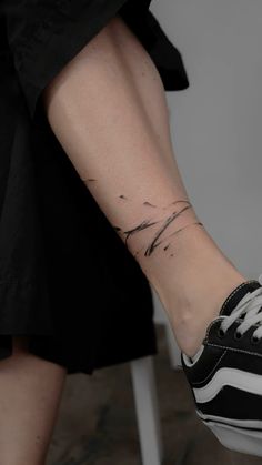 a woman's foot with a small wave tattoo on her left ankle and the word love written in black ink