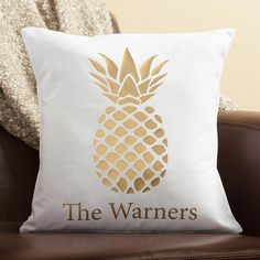 a white pillow with a gold pineapple on it