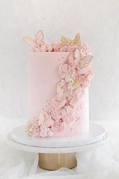 a pink and gold wedding cake with flowers on top