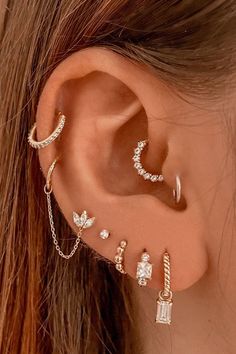 a woman wearing three different ear piercings