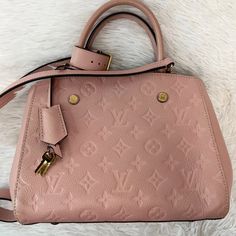 100% Authentic Louis Vuitton Empreinte Montaigne Bb In Rose Poudre. This Chic Tote Is Crafted Of Textured Louis Vuitton Monogram Embossed Leather In Light Pink. The Bag Features Rolled Leather Top Handles And An Optional Leather Shoulder Strap With Polished Brass Clasps. This Bag Includes A Padlock, Keys, And Hanging Clochette. The Top Is Open To A Partitioned Leather And Pink Striped Fabric Interior With A Central Zipper Compartment And Patch Pockets. In Excellent Preloved Condition. Light Scuf Pink Luiviton Bag, Pink Louis Vuitton Purse, Louis Vuitton Purse Pink, Light Pink Louis Vuitton Bag, Pink Luxury Bags With Gold-tone Hardware, Louis Vuitton Empreinte, Authentic Louis Vuitton, Leather Top, Patch Pocket