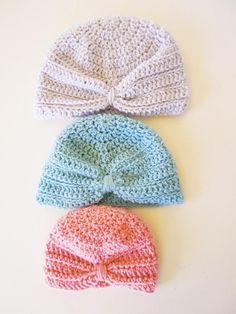 three crocheted hats are laying next to each other