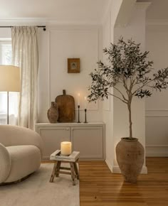 a living room filled with furniture and a tree in the middle of it's center