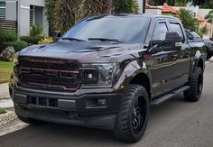 a black truck is parked on the side of the road