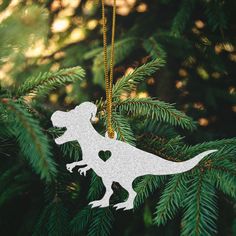 a dinosaur ornament hanging from a christmas tree