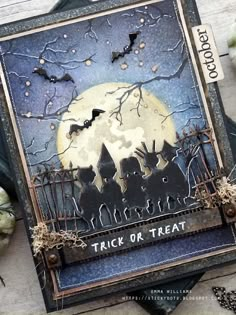 an altered halloween card with bats, pumpkins and the words trick or treat on it