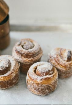 several powdered doughnuts sitting on top of a counter