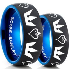 two black and blue wedding rings with crowns on each side, one has the word sorry to