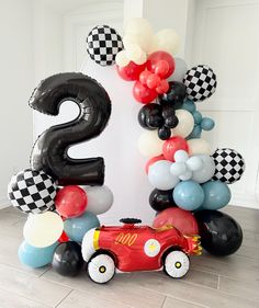 a birthday decoration with balloons and an air balloon number 2 in the shape of a race car