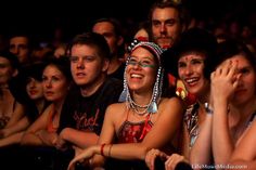 a group of people sitting next to each other in front of a crowd at a concert