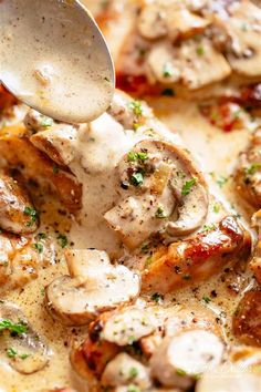 a spoon scooping some food out of a pan with chicken and mushrooms on it