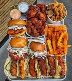 a tray filled with lots of different types of food next to fries and coleslaw