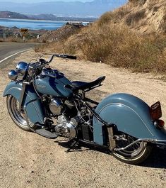 a blue motorcycle parked on the side of a road