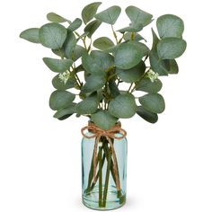 a glass vase filled with green leaves and flowers