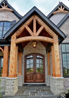 the front entrance to a large home with wood trimming