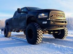 a large black truck is parked in the snow