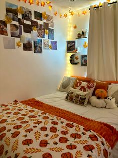 a bedroom decorated in fall colors with pumpkins and leaves on the wall above the bed