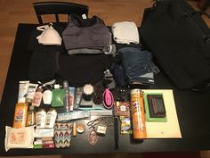 an assortment of personal care items laid out on a table next to a backpack and purse