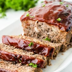 sliced meatloaf on a plate with ketchup and parsley in the background