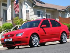 a red car parked in front of a house