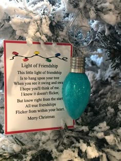 a light bulb ornament hanging from a christmas tree with a poem on it