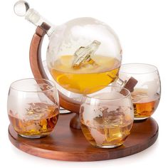 an assortment of whiskey glasses on a wooden tray with a globe in the middle,