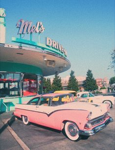 an old pink car parked in front of a drive thru diner with cars outside it