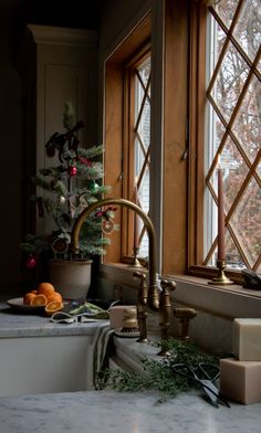 a christmas tree is in the window sill next to a sink and counter top