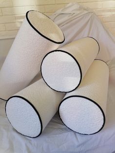 four white toilet rolls sitting on top of a bed