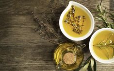 two white bowls filled with olive oil and herbs