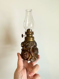 a person holding a small lamp in their hand