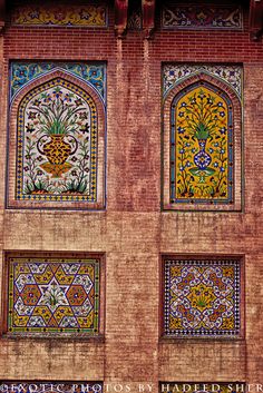 an old building with decorative windows and tile work on the outside wall is shown in this photograph