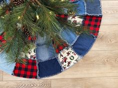 a christmas tree skirt made out of jeans and plaid fabric with pine cones on top