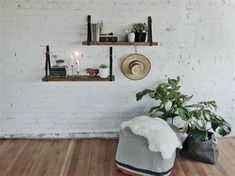 a room with white brick walls and wooden flooring, two shelves on the wall