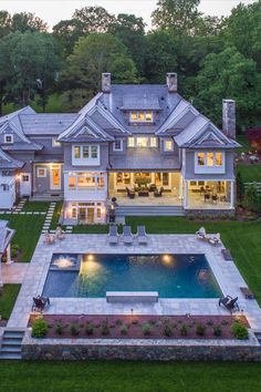 an aerial view of a large house with a swimming pool in the middle of it