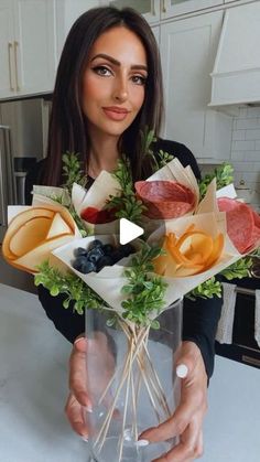 a woman holding a vase filled with different types of fruits and vegtables