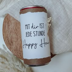 a jar with some writing on it sitting on a white furnishing area next to a pillow