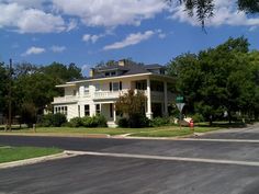 a large white house sitting on the side of a road