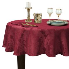 a red table cloth with two candles on it