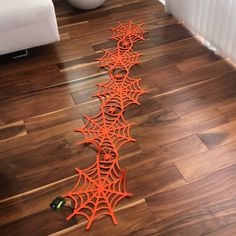 an orange spider web is on the floor in front of a white radiator