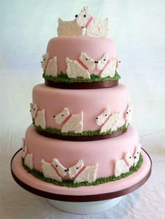 a three tiered cake with pink icing and white frosting animals on it